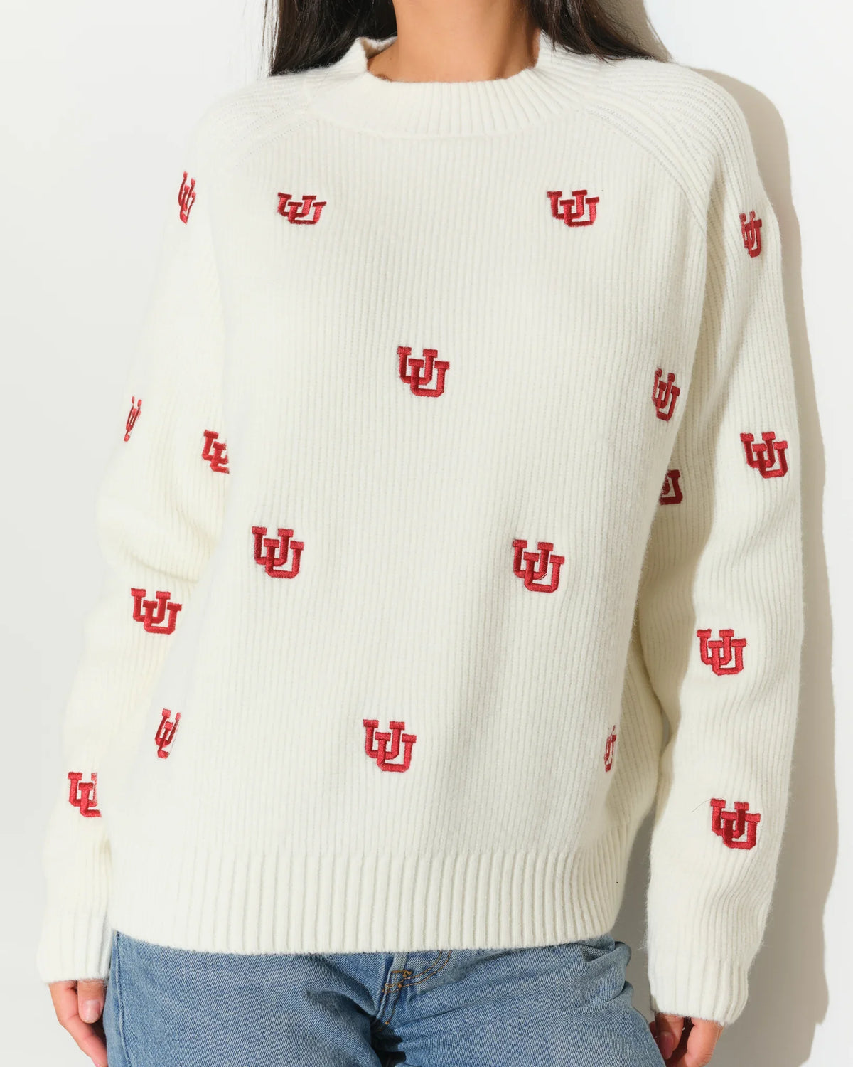 Ivory Utah Utes fisherman sweater with allover red embroidered UU logos, featuring a crew neck and ribbed cuffs.