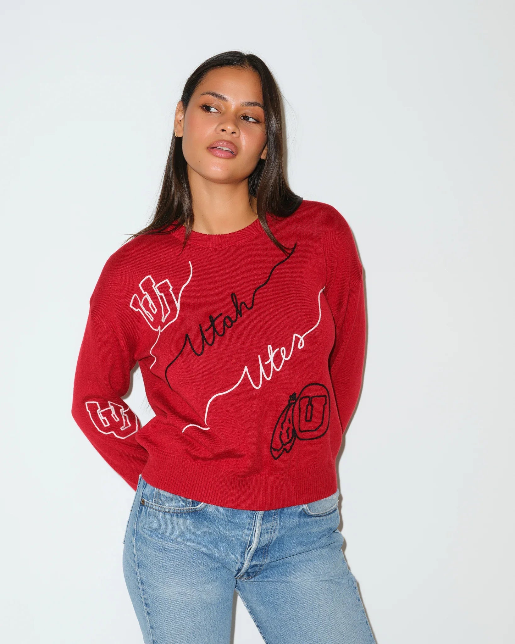 Red Utah Utes crewneck sweater featuring cursive "Utah Utes" script and logo patches on the sleeves and chest.