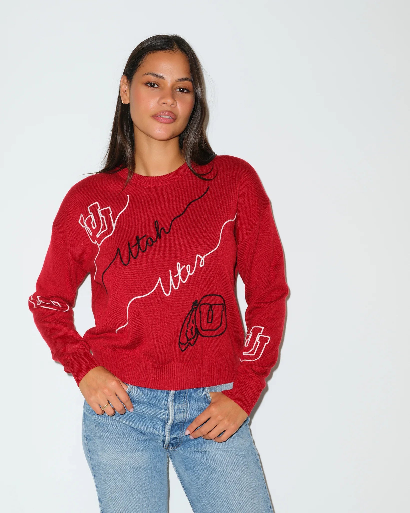 Red Utah Utes crewneck sweater featuring cursive "Utah Utes" script and logo patches on the sleeves and chest.