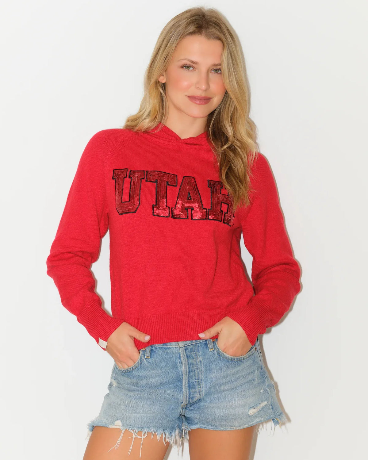 Red Utah Utes women's cropped pullover hoodie featuring sequin block letter "UTAH" graphic across the chest.