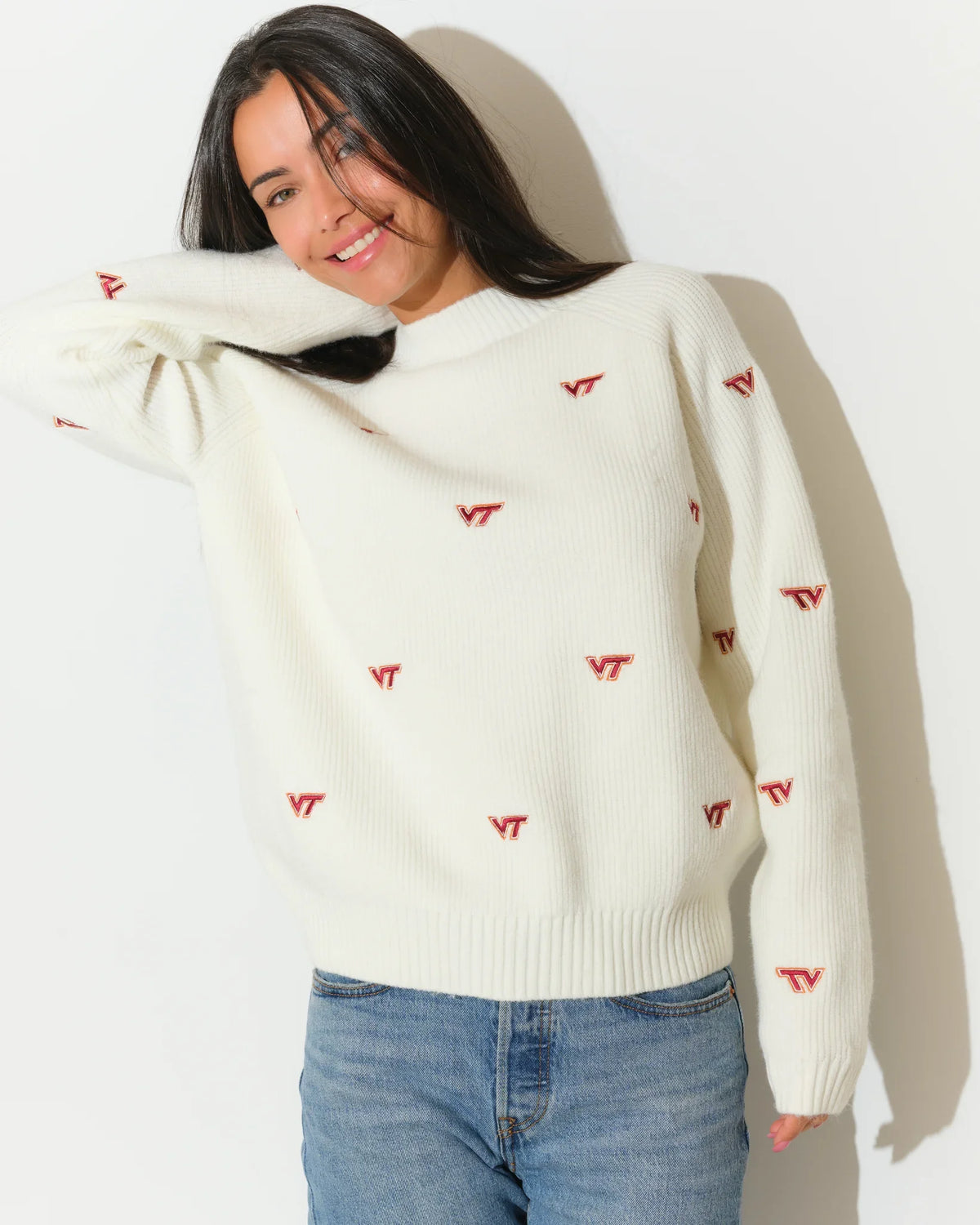 Ivory Virginia Tech fisherman sweater featuring an allover red VT logo pattern, modeled with a relaxed crew neck fit and long sleeves.