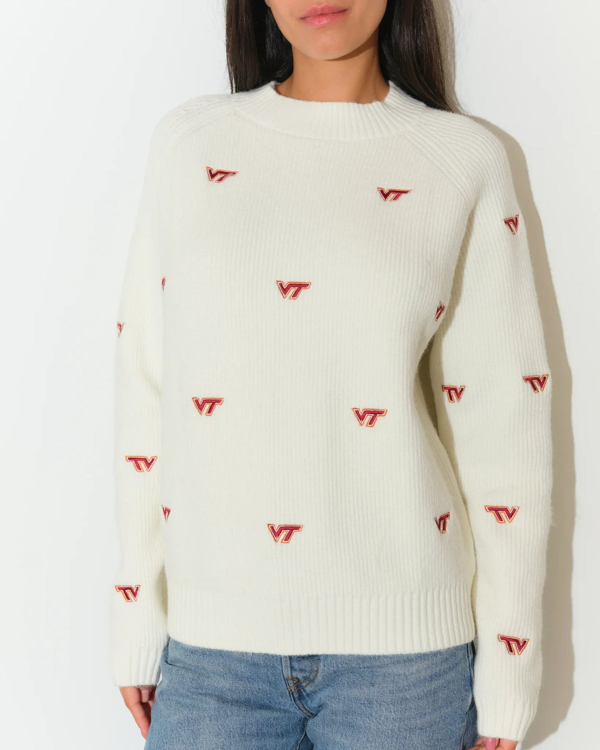 Ivory Virginia Tech fisherman sweater featuring an allover red VT logo pattern, modeled with a relaxed crew neck fit and long sleeves.