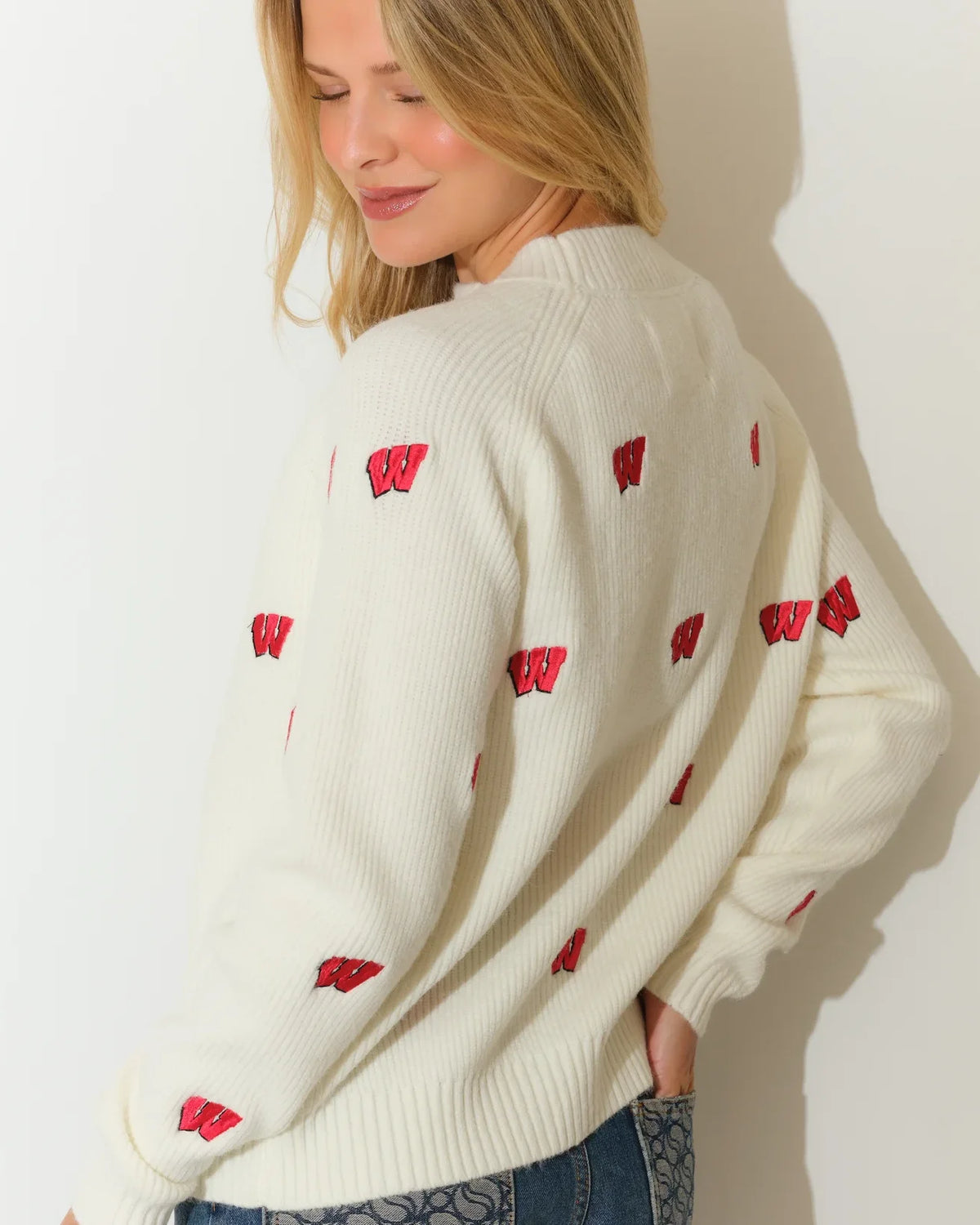 Ivory Wisconsin Badgers fisherman sweater with allover red Badger logo pattern, featuring a relaxed fit and ribbed cuffs.