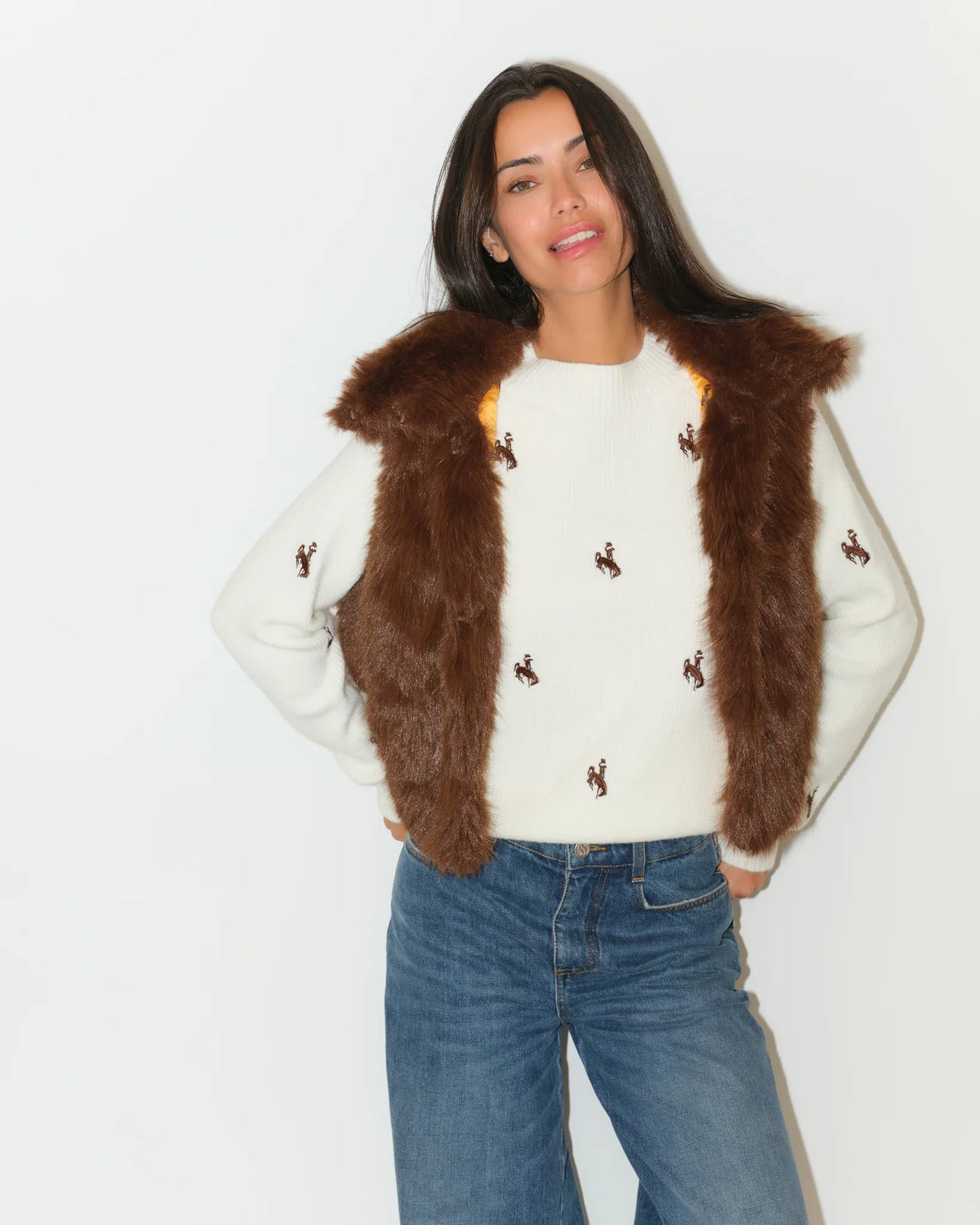Brown faux fur Wyoming Cowboys vest with gold printed lining, shown open over a white Cowboys-embroidered sweater.