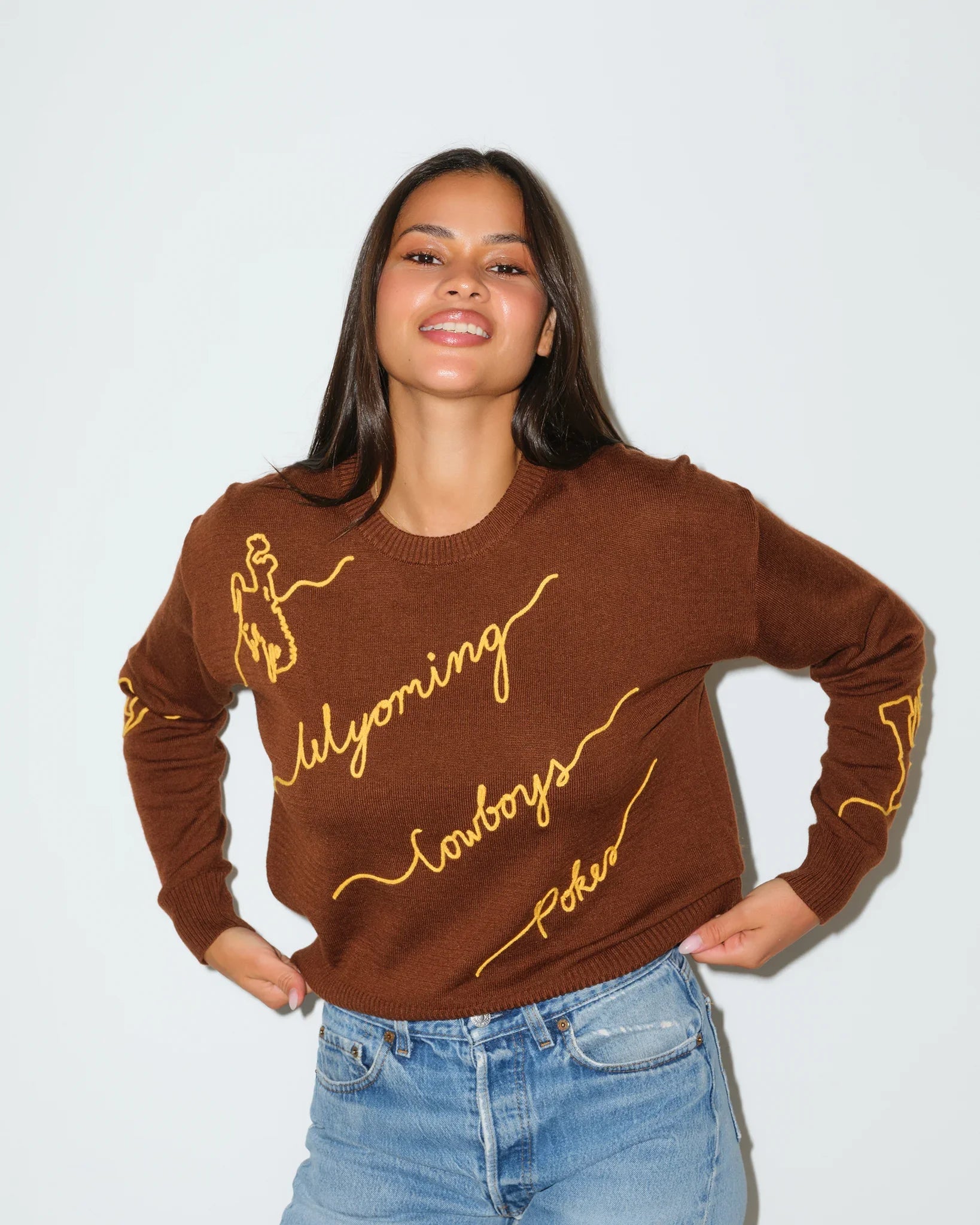 Brown Wyoming Cowboys Love Letter Sweater with gold cursive "Wyoming Cowboys" script embroidery across the front and sleeve.