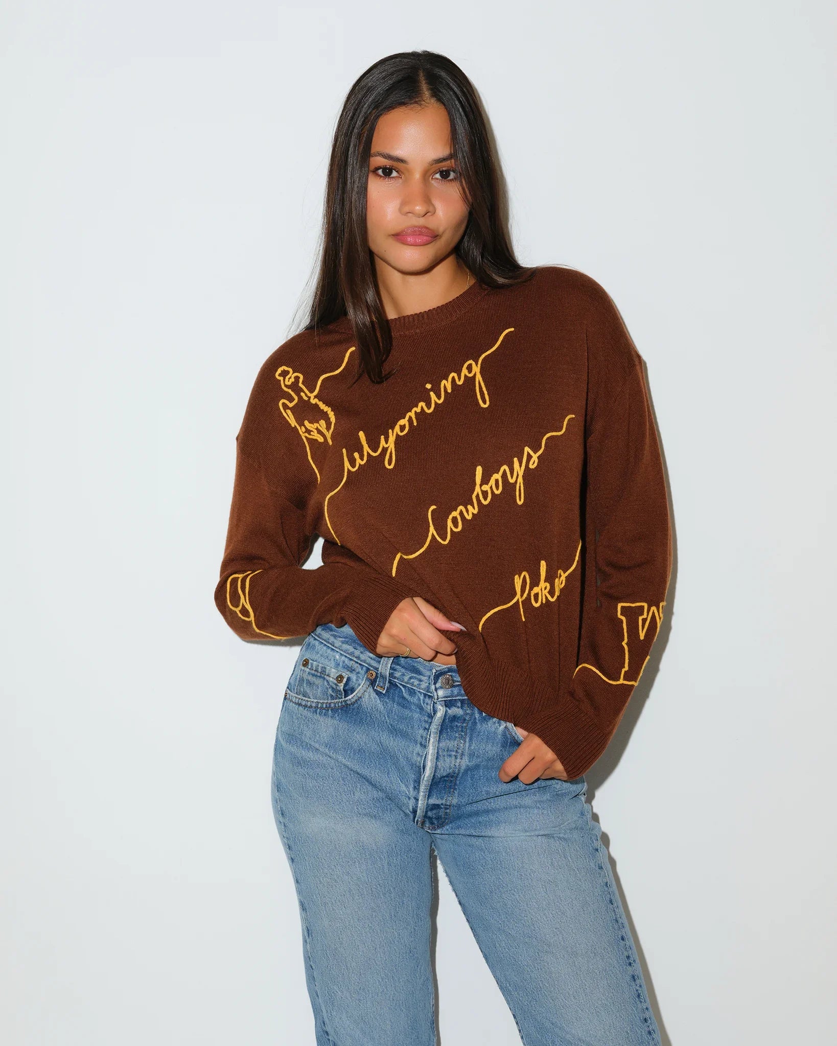 Brown Wyoming Cowboys Love Letter Sweater with gold cursive "Wyoming Cowboys" script embroidery across the front and sleeve.