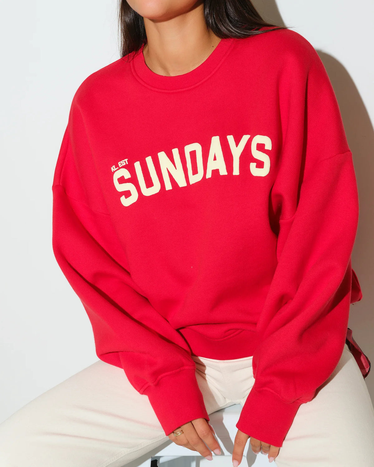 Red KadyLuxe Balloon Sleeve Crew sweatshirt with "SUNDAYS" graphic lettering across the chest, featuring a relaxed fit and crew neckline.