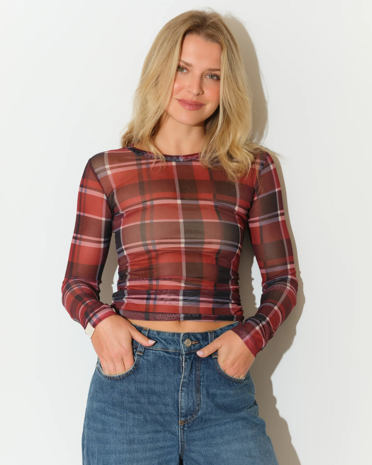 Red plaid mesh long sleeve crop top by KadyLuxe, featuring a fitted silhouette with a classic crew neckline and sheer fabric detail.