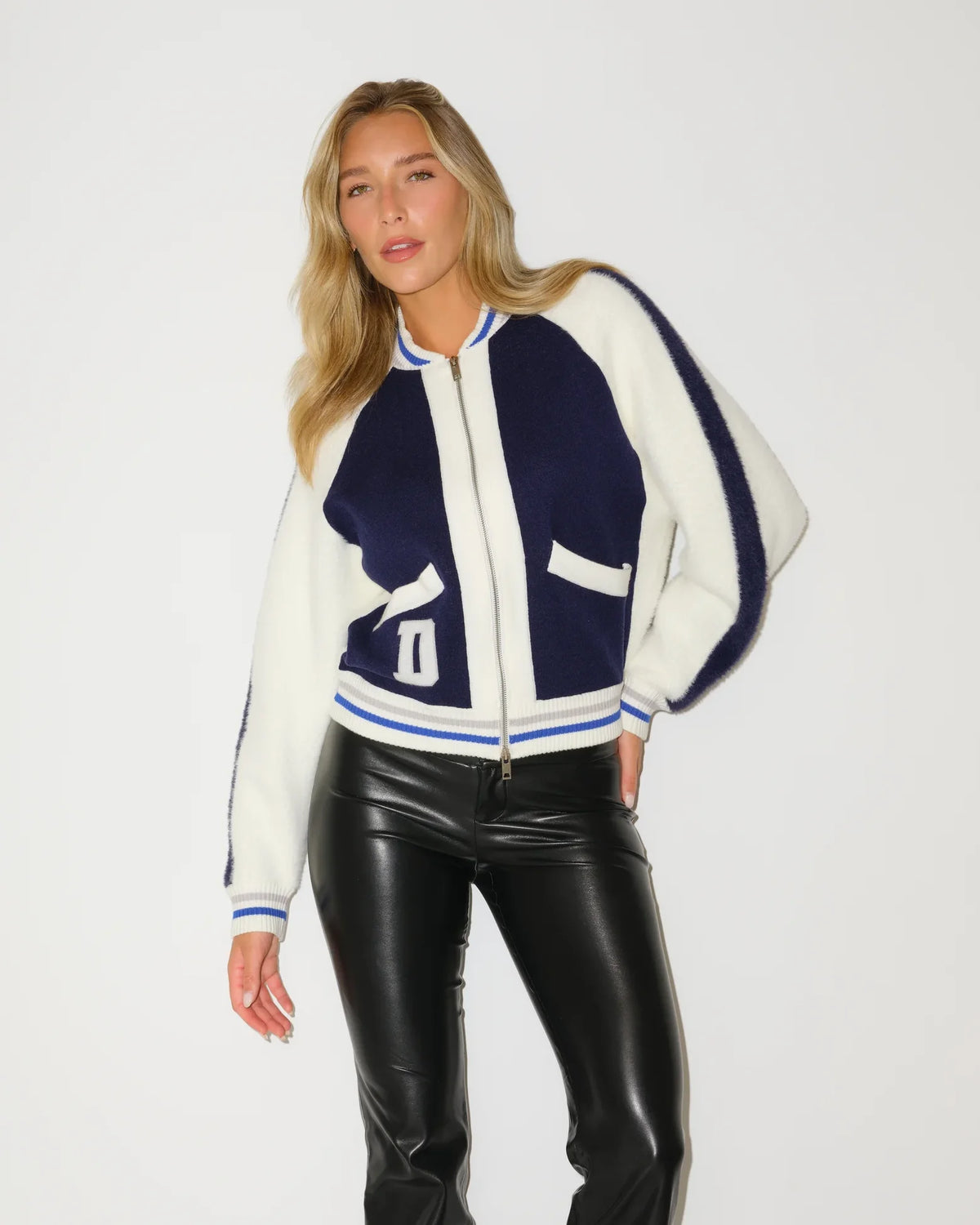 Navy and white Dallas Cowboys bomber jacket with a varsity-style "D" patch, contrast stripe trim, and zip-front closure.