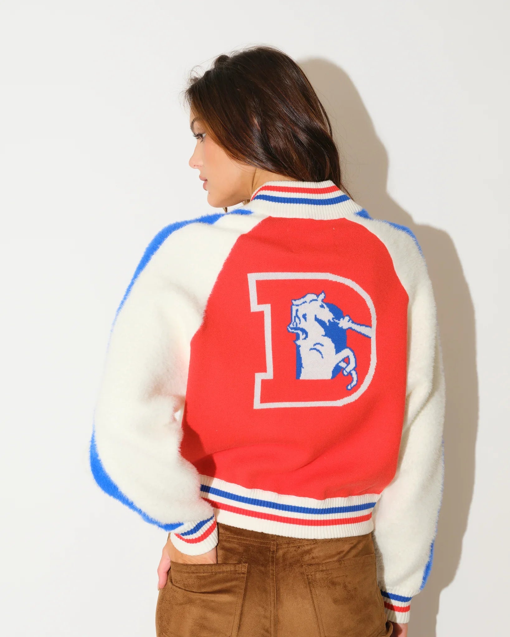 Orange Denver Broncos faux fur knit bomber jacket with red and blue colorblock panels, stripe trim, and a large "B" logo on the chest.