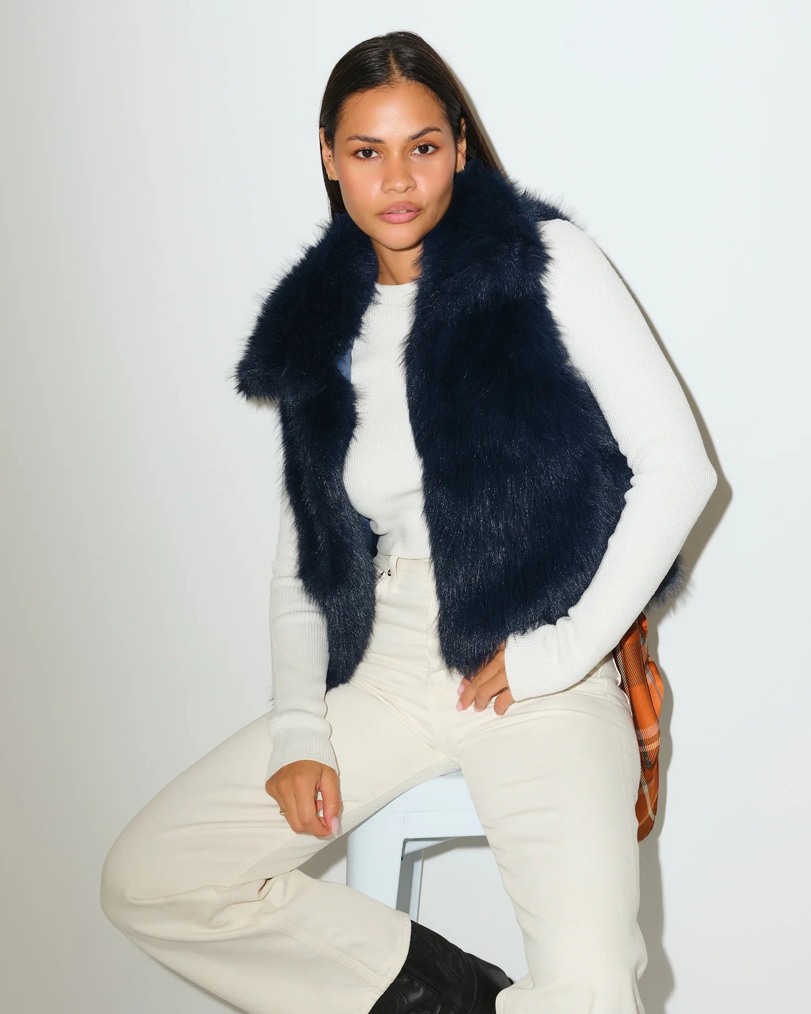 Navy Denver Broncos faux fur vest with a fluffy, open-front silhouette, styled over a white outfit.