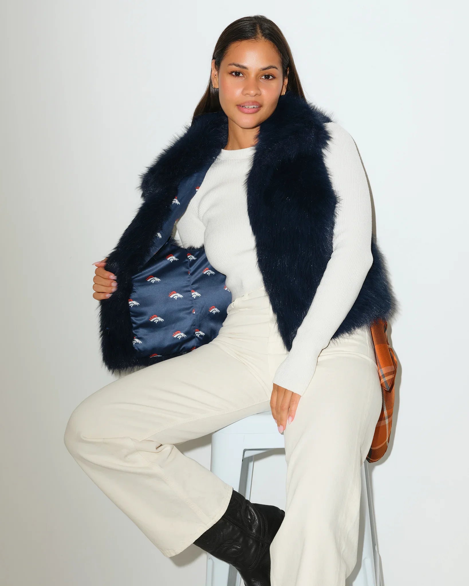 Navy Denver Broncos faux fur vest with a fluffy, open-front silhouette, styled over a white outfit.