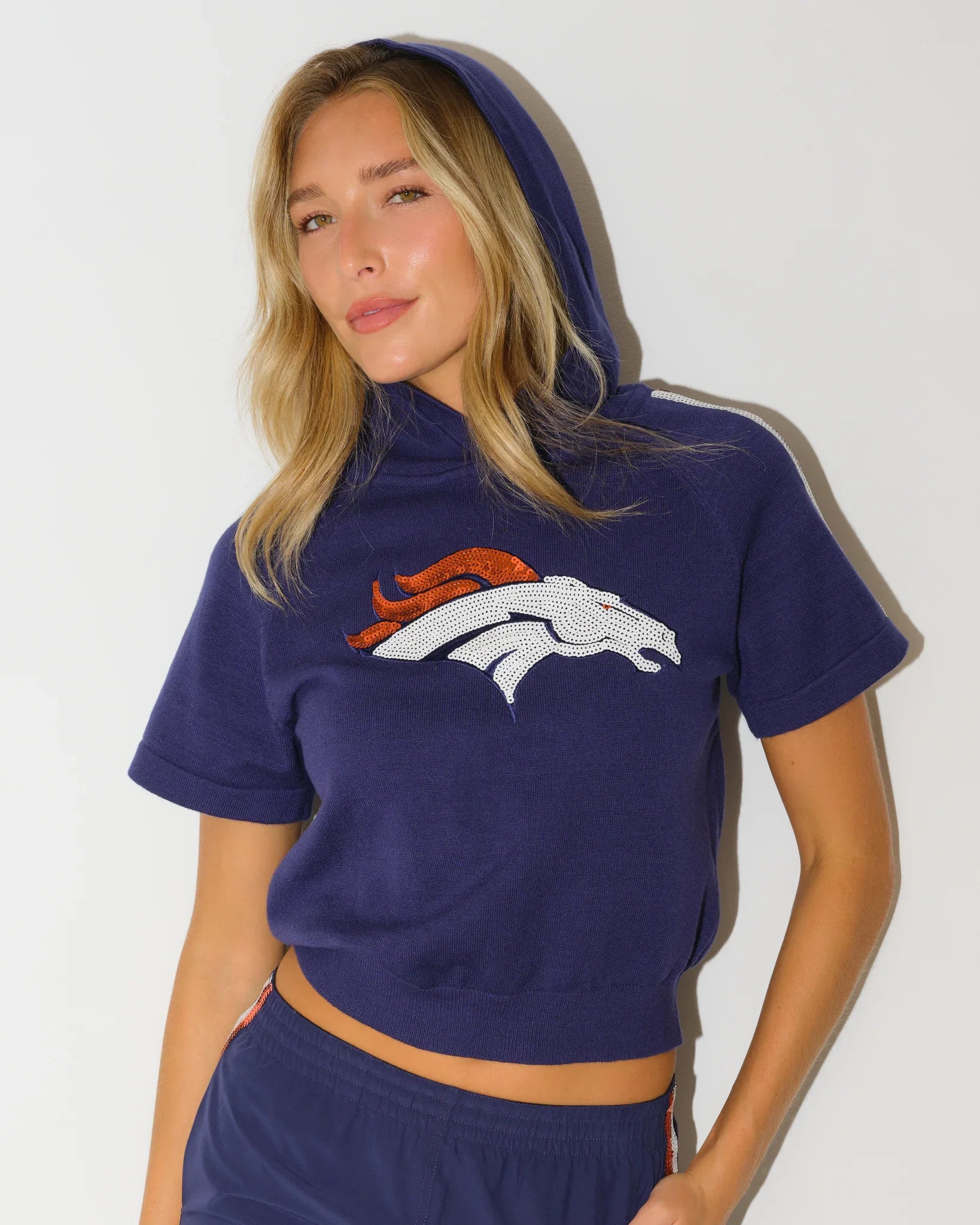 Navy Denver Broncos sequin sweater featuring a bold sequined logo on the chest, styled with matching navy pants.