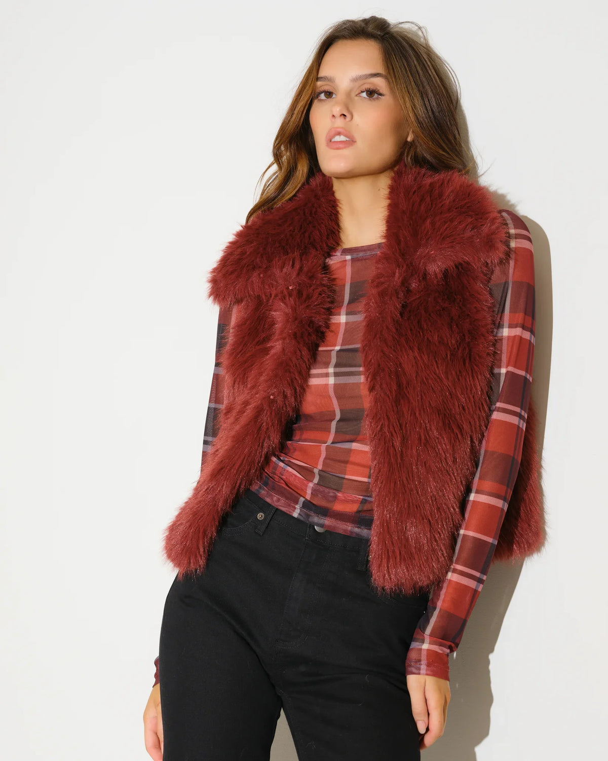 Oxblood reversible faux fur vest by KADYLUXE, shown with plush texture on the fur side and a sleeveless silhouette.